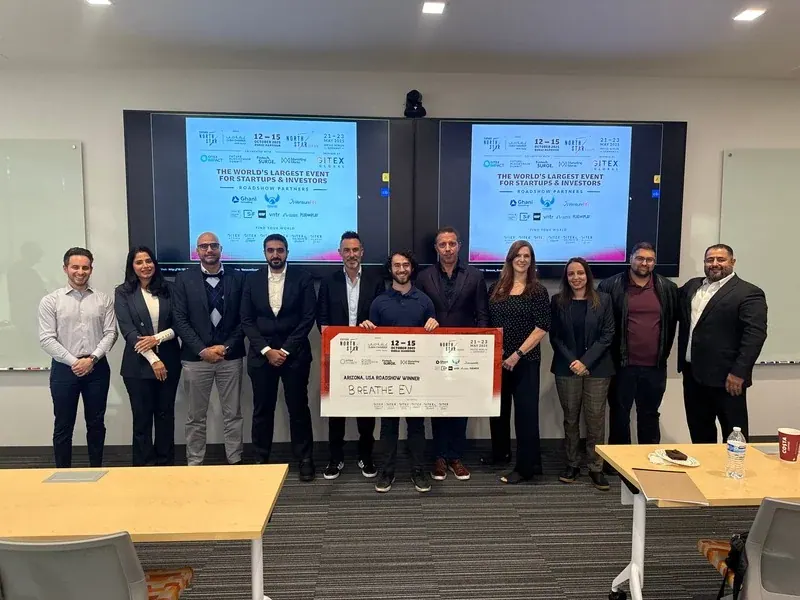 A startup team presented with an oversized prize cheque at a Dubai Tech Experience event
